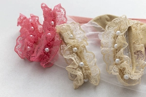 Vue détaillée de chaussettes en dentelle rose et beige avec des perles délicates