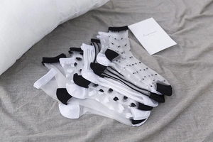 Dettaglio flat lay di calze in rete velata con pois neri e bianchi e motivi a cuore eleganti