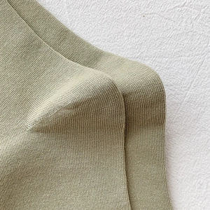 Close-up of olive green ribbed knit fabric texture on cotton mid-calf socks