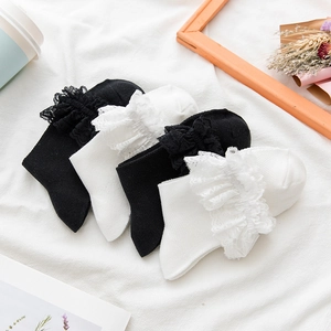 Detail of white and black Lolita lace trim mid-calf socks with delicate ruffle edges