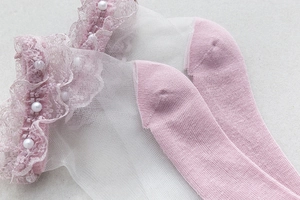 Détails de chaussettes en dentelle rose et blanc avec maille fine et perles décoratives