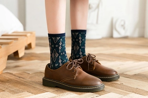 Detail of knit crew socks with blue argyle pattern paired with vintage brown leather shoes