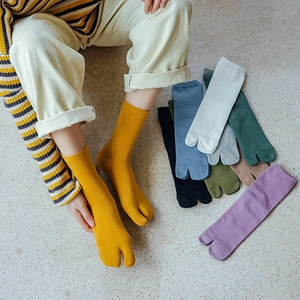 Flat lay of colorful split-toe cotton socks in nine vibrant colors for tabi shoes