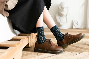 Detail of vintage argyle mid-calf socks paired with classic brown derby leather shoes