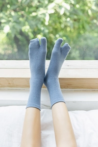 Detail of blue cotton Tabi socks with two-toe design and breathable knit texture