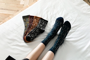 Close-up of retro argyle pattern mid-calf cotton socks in vintage color variety