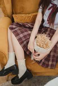 Close-up of white JK style mid-calf socks with ruffles and bows with black loafers