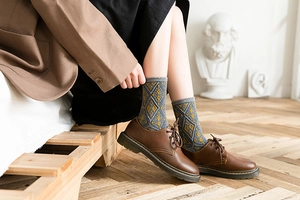 Detailed view of argyle patterned mid-calf socks with vintage British style and grey cuff