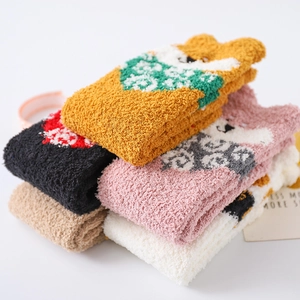 Close-up of thick coral fleece socks with cute cartoon animal faces and 3D ears