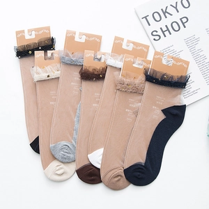 Flat lay of sheer mesh crew socks with lace trim and gold star sequins in multiple colors