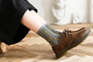 Detail of retro argyle knit socks in gray and yellow with comfortable ribbed cuffs