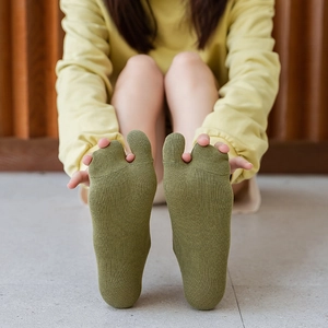 Detailed view of grass green two-toe socks with high-quality knitted cotton texture