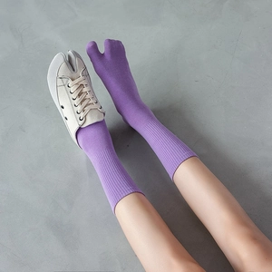 Calze Tabi viola in cotone indossate con scarpe da ginnastica bianche con punta divisa