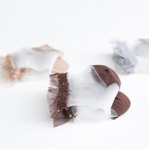 Detailed macro view of sheer lace socks with delicate golden star patterns on mesh fabric