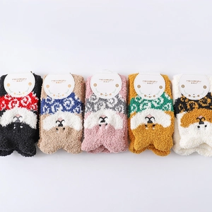 Close-up of five pairs of thick coral fleece winter socks with cartoon animal faces