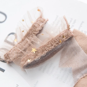 Detail of sweet mesh socks featuring double-layered lace with gold star sequins