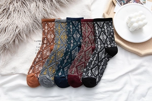 Detailed flat lay of five pairs of vintage argyle knit mid-calf socks in autumn colors