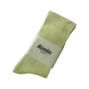 Mint green cotton mid-calf socks with Aimin House paper wrap on white background