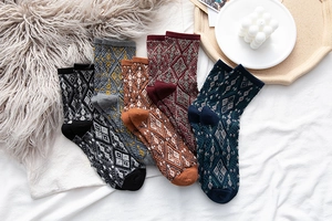 Flat lay of five pairs of vintage argyle mid-calf cotton socks in various warm colors