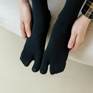 Elastic black Tabi socks with split-toe design for women, shown in high-quality knit texture