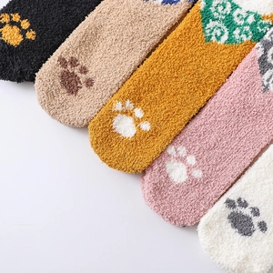 Close-up of five colorful coral fleece socks with cute cartoon cat paw patterns