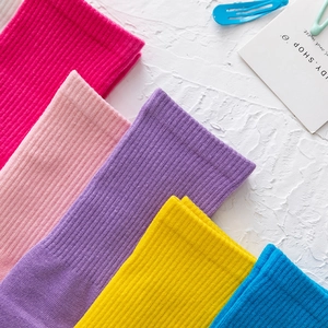 Dettaglio di calzini tabi a coste in maglia dai colori vivaci rosa, giallo e blu