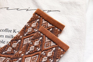 Detailed view of vintage knit socks showing geometric jacquard patterns and thick texture