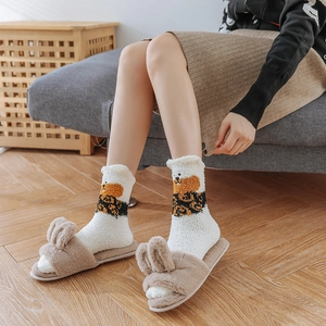 Close-up of cozy white plush puppy socks paired with rabbit ear indoor slippers