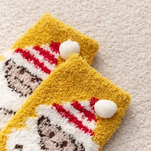 Close-up of yellow coral fleece Christmas sock with 3D cartoon plush and striped hat