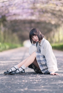 Close-up of white cotton knee-high socks paired with a pleated plaid skirt and Mary Janes