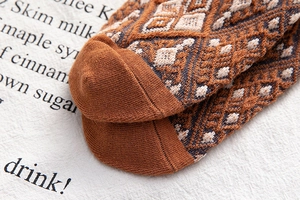 Detailed macro view of retro diamond pattern knit socks with reinforced toe stitching