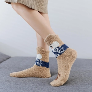 Detail of warm coral fleece winter socks with cute cartoon dog embroidery and jacquard pattern