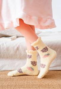 Detailed view of yellow coral fleece socks with bear pattern and frilly cuff design