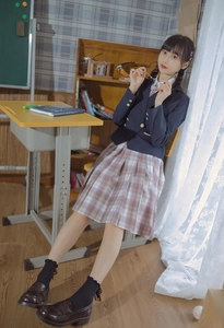 Detail of JK style navy blazer with gold buttons, plaid skirt and black lace socks