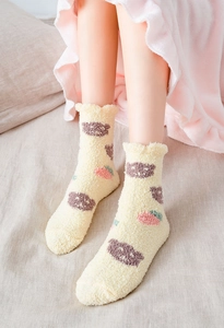 Close-up of thick coral fleece socks with brown bear and pink strawberry patterns
