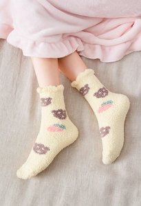 Detail of coral fleece socks with purple bear and strawberry patterns and ruffled cuffs