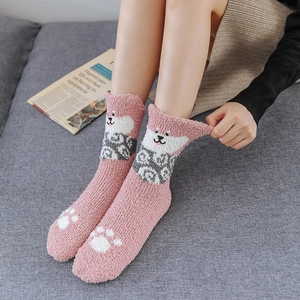Close-up of pink coral fleece thermal socks featuring cute puppy cartoon and paw prints