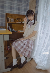 Detailed look at Lolita style white ruffled socks paired with a pleated plaid skirt and shoes