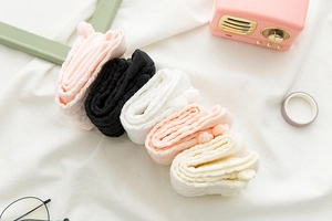 Dettaglio di cinque paia di calze Lolita con trama in maglia traforata in delicate tinte pastello