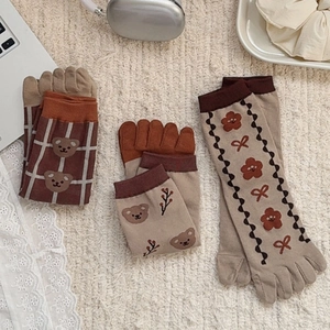 Detailed flat lay of three retro bear pattern cotton five-finger socks in beige and brown