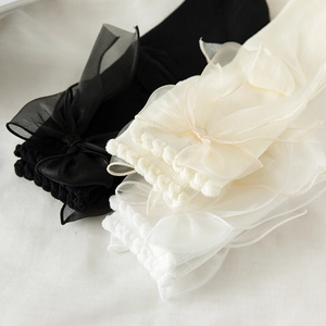 Détail de chaussettes Lolita avec de grands nœuds en organza et des bords à volants