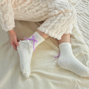 Plush white coral fleece winter socks with purple ribbon bows for cozy home wear