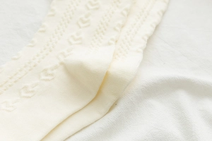 Dettaglio macro di calze Lolita bianco crema con motivi a maglia traforata a forma di V