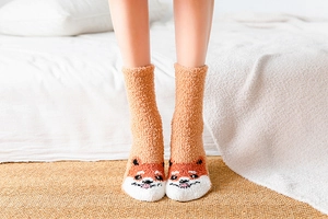 Details von dicken Korallenvlies-Socken mit süßem orangefarbenem Fuchsmuster für Winter