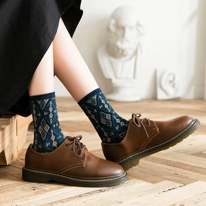 Retro argyle knit mid-calf socks paired with brown leather derby shoes in a vintage style