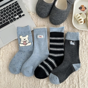 Detail of four assorted thick winter wool socks with cartoon embroidery and stripes