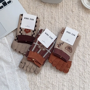 Detailed macro view of cotton five-finger socks with floral and plaid bear patterns