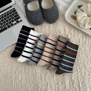 Detailed close-up of six pairs of striped cotton crew socks in vintage autumn colors