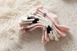 Close-up of thick pink and white coral fleece socks featuring cute polka dot patterns