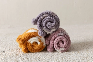 Detailed texture of thick coral fleece winter socks in purple yellow and pink colors